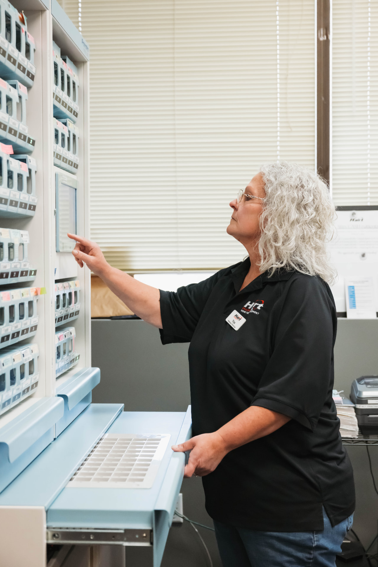 Hart Pharmacy technician using the automated dispensing cabinet at the Comcare location